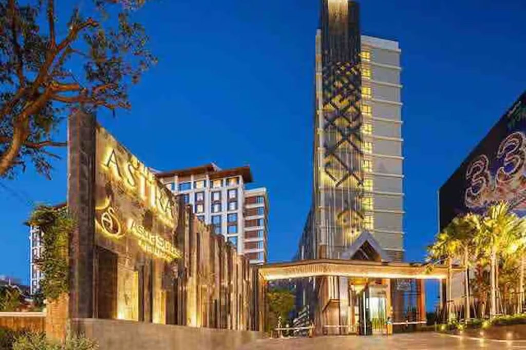 Illuminated entrance and exterior of the Astra condominium in Chiang Mai at dusk.