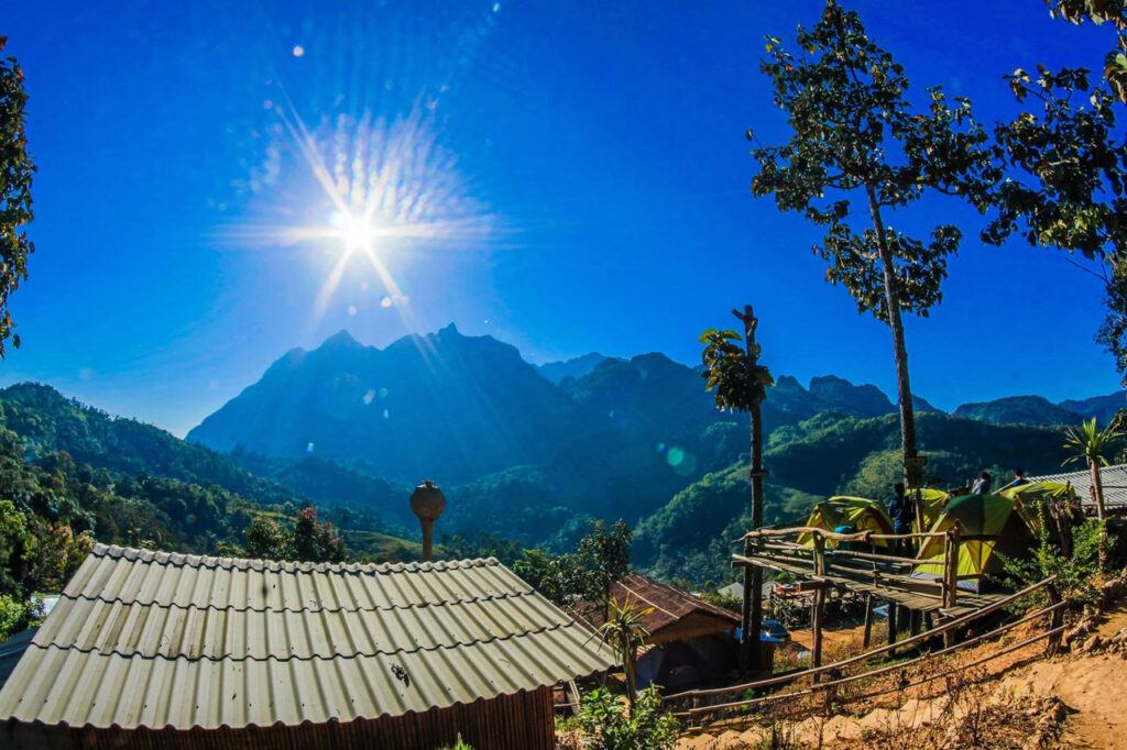 Morning sun over Doi Luang Chiang Dao mountain with tents and forest view from a hillside campsite in northern Thailand