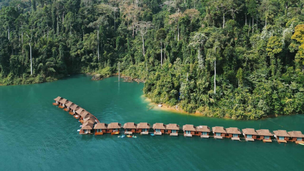 Floating raft-style bungalows on Cheow Lan Lake with limestone cliffs and rainforest in Khao Sok National Park, Thailand