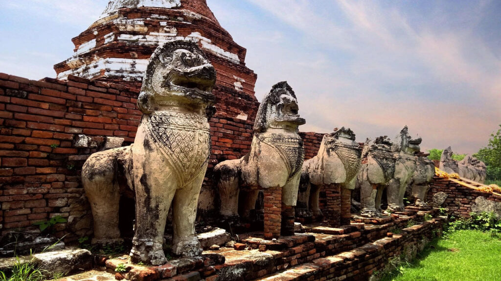 Line of stone lion guardians at Wat Thammikarat, Ayutthaya, Thailand