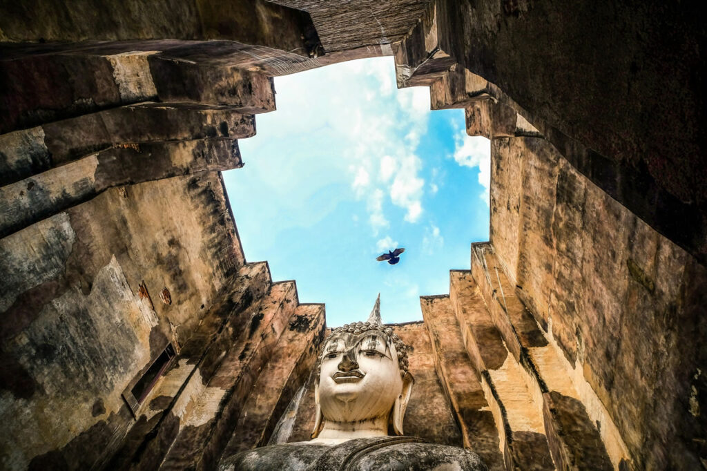 Looking up at the giant Buddha statue inside Wat Si Chum at Sukhothai Historical Park