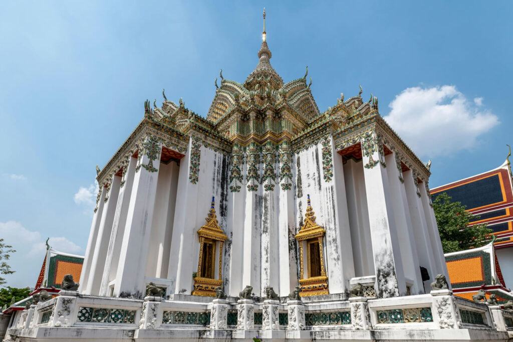 White ordination hall with colorful roof details at Wat Pho.