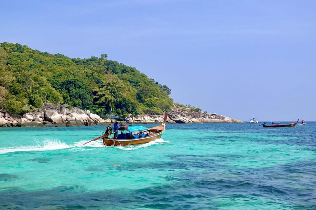 Traditional Thai longtail boat cruising in turquoise waters near Koh Lipe, Thailand