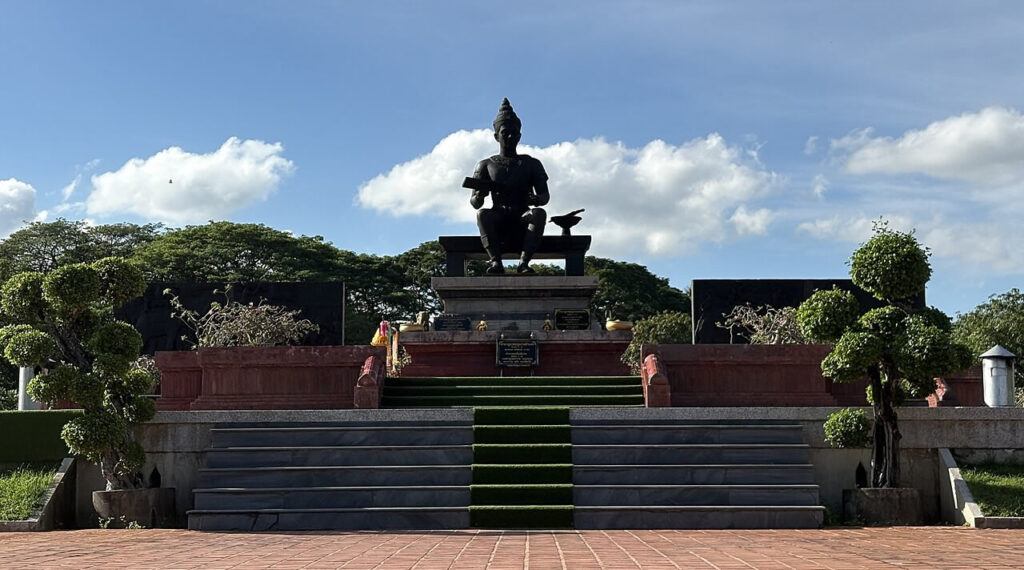 Statue of King Ramkhamhaeng the Great at Sukhothai Historical Park, Thailand, under a bright blue sky