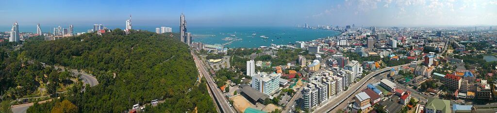 Panoramic view of Pattaya City with Pratumnak Hill, high-rise buildings, and Pattaya Bay.
