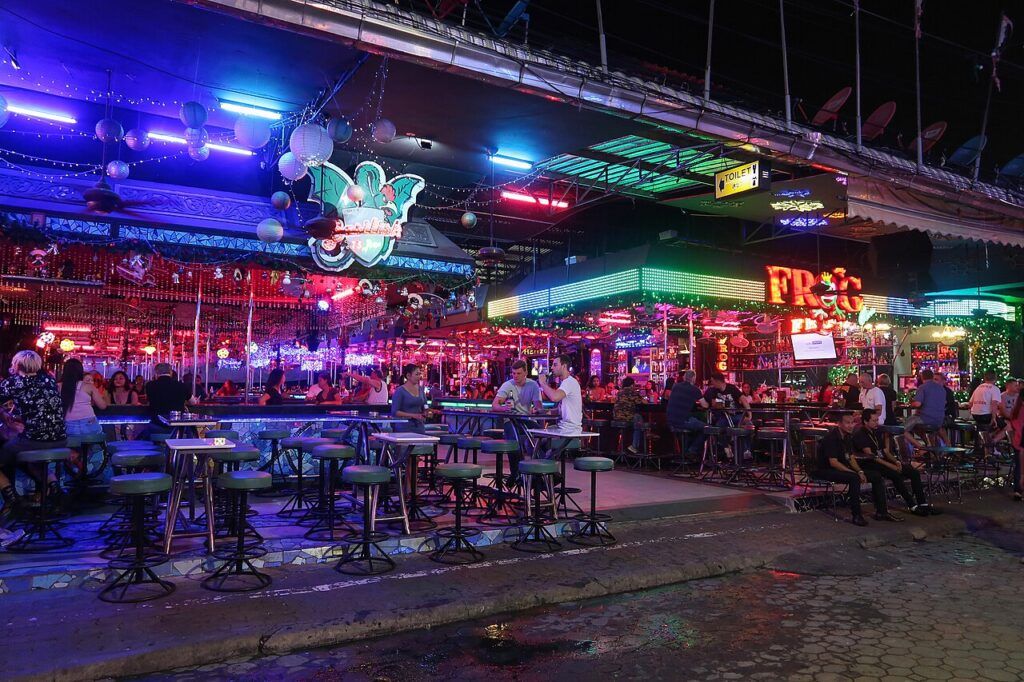Neon-lit bars and people enjoying the nightlife on Walking Street in Pattaya.