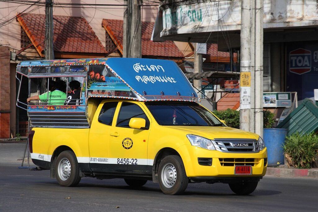 Yellow songthaew pickup truck used for local transport in Hat Yai, southern Thailand