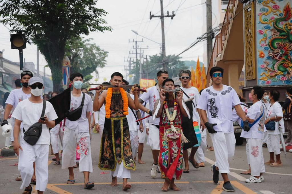 Spirit medium accompanied by devotees during a Phuket Vegetarian Festival procession in Phuket Town