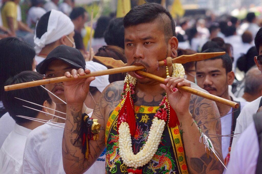 Spirit medium carrying ritual objects during a procession at the Phuket Vegetarian Festival