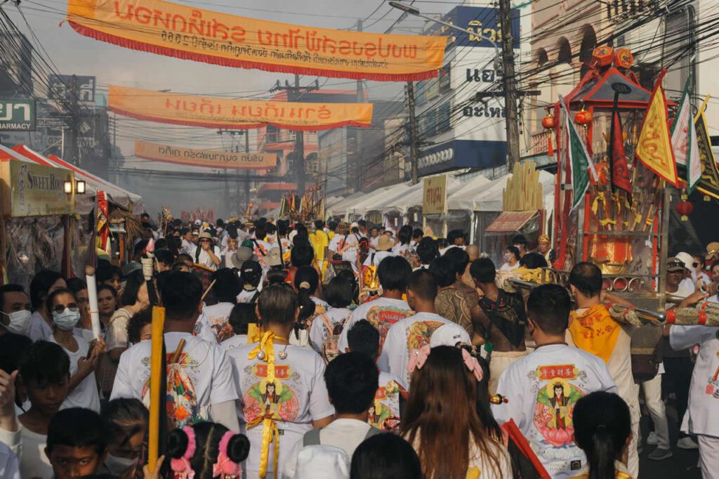 Crowds gathering along a street procession during the Phuket Vegetarian Festival in Phuket Town