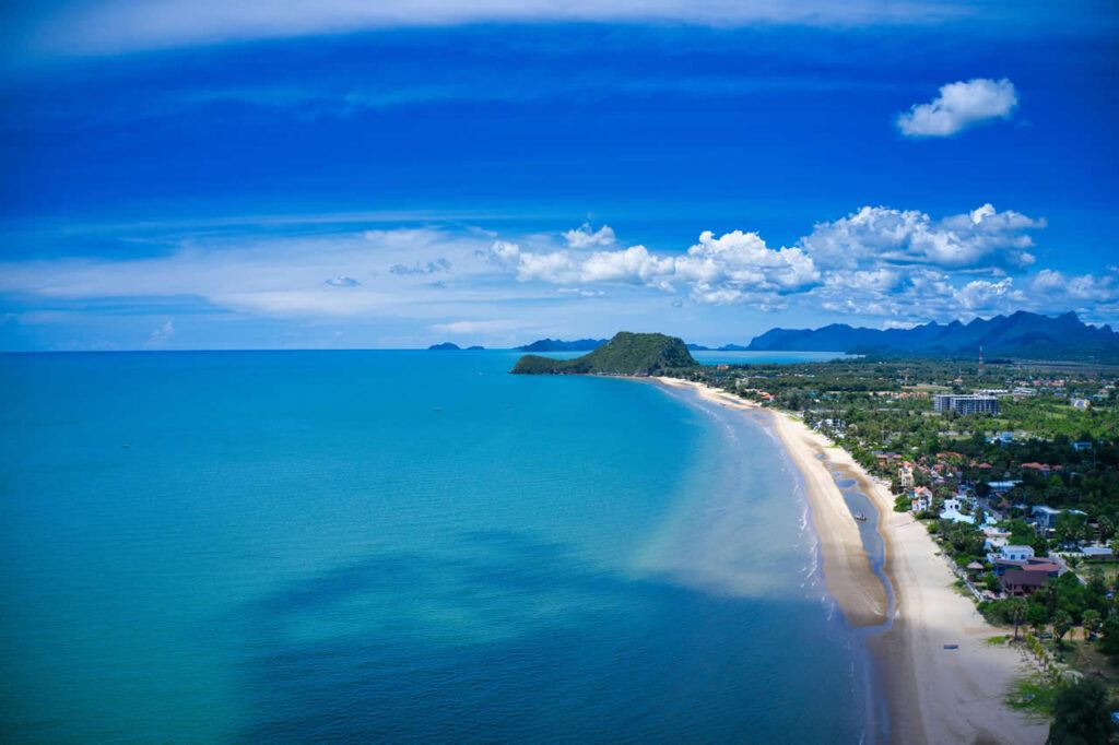 Aerial view of Cha-am Beach in Thailand showing long sandy coastline and seaside town