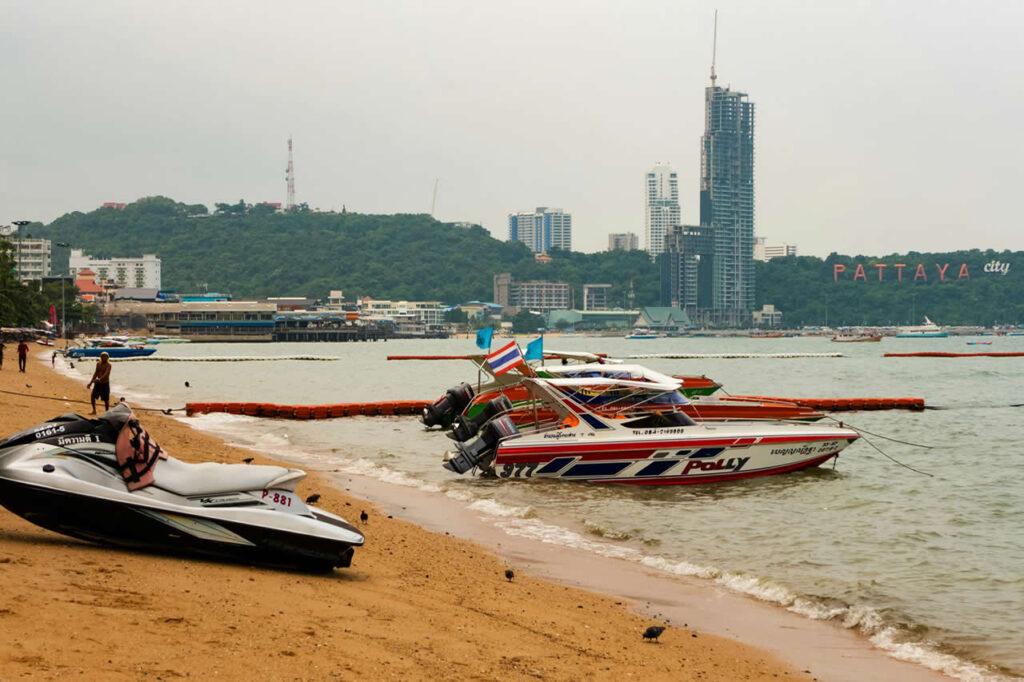 Speedboats on Pattaya Beach with city skyline and high-rise buildings in the background