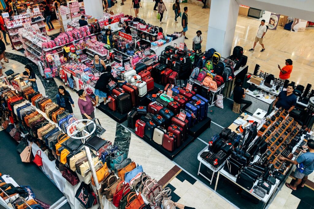 Retail stalls selling bags and luggage inside a shopping mall in Thailand