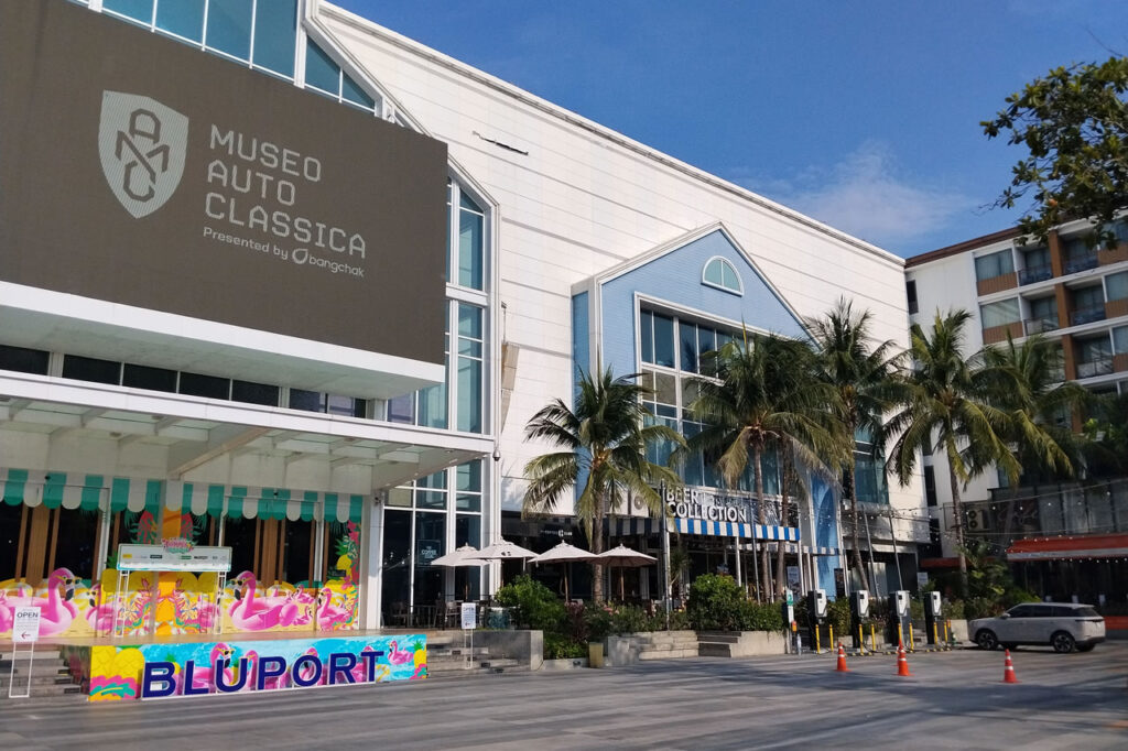 Exterior view of Bluport Hua Hin shopping mall with palm trees, modern architecture, and the Museo Auto Classica entrance in Hua Hin, Thailand.