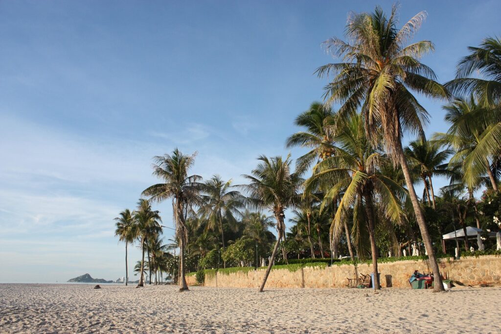 Hua Hin beach with palm trees and wide sandy coastline in Thailand