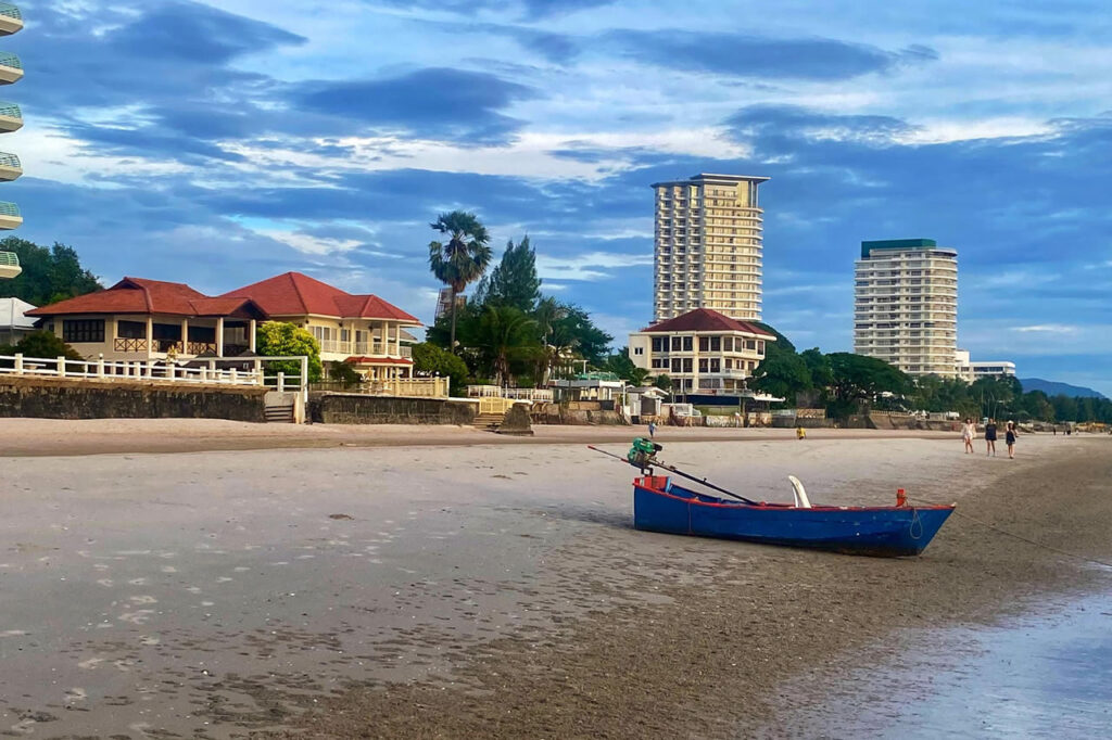 Hua Hin beach with local boat and hotels along the shoreline
