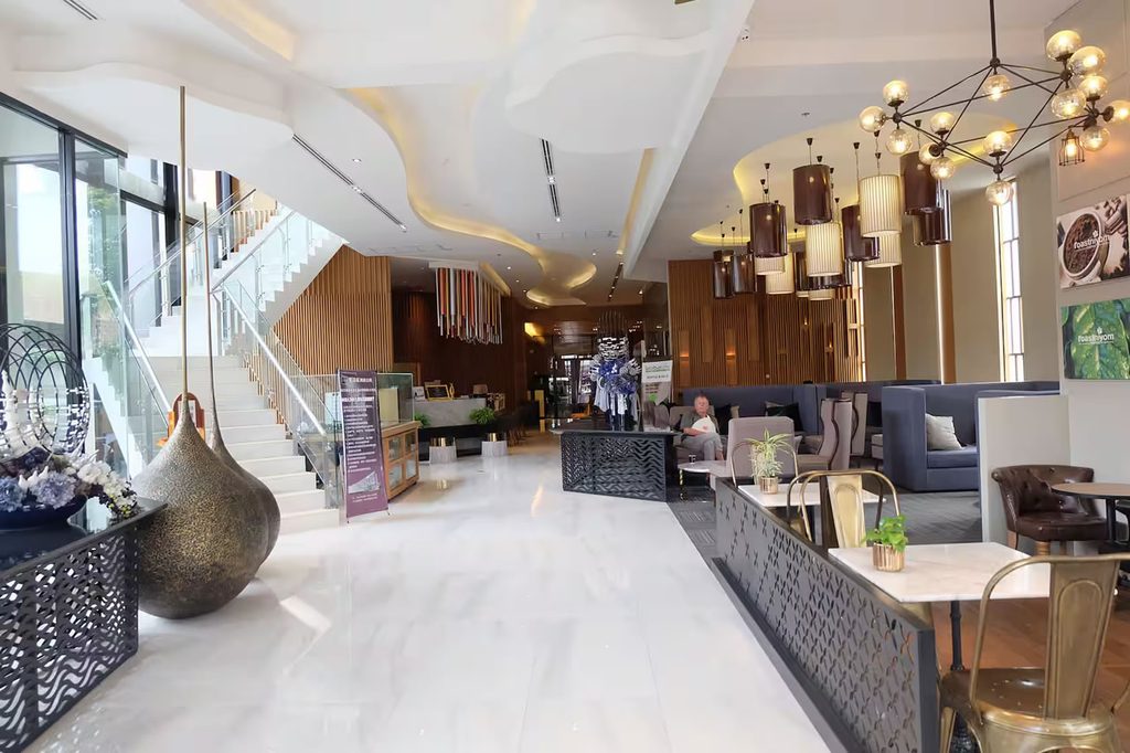Lobby at The Astra condominium in Chiang Mai, with seating areas, decorative lighting and a staircase