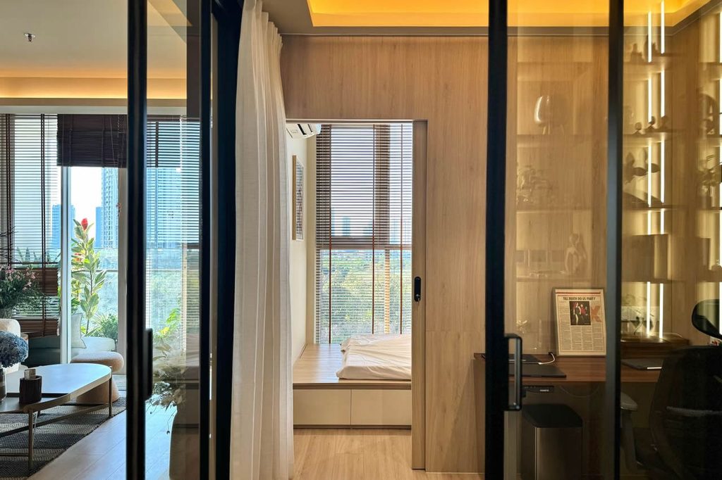 Condo interior with glass partitions separating the bedroom, living area and workspace