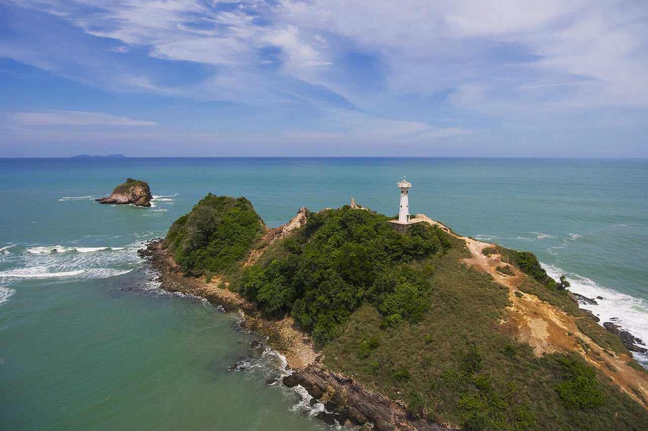 White lighthouse on the rocky Laem Tanod headland, surrounded by turquoise sea in Mu Ko Lanta National Park.