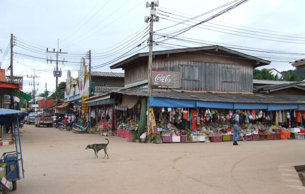 Street scene in Saladan, Koh Lanta, with clothing and souvenir shops in wooden buildings.