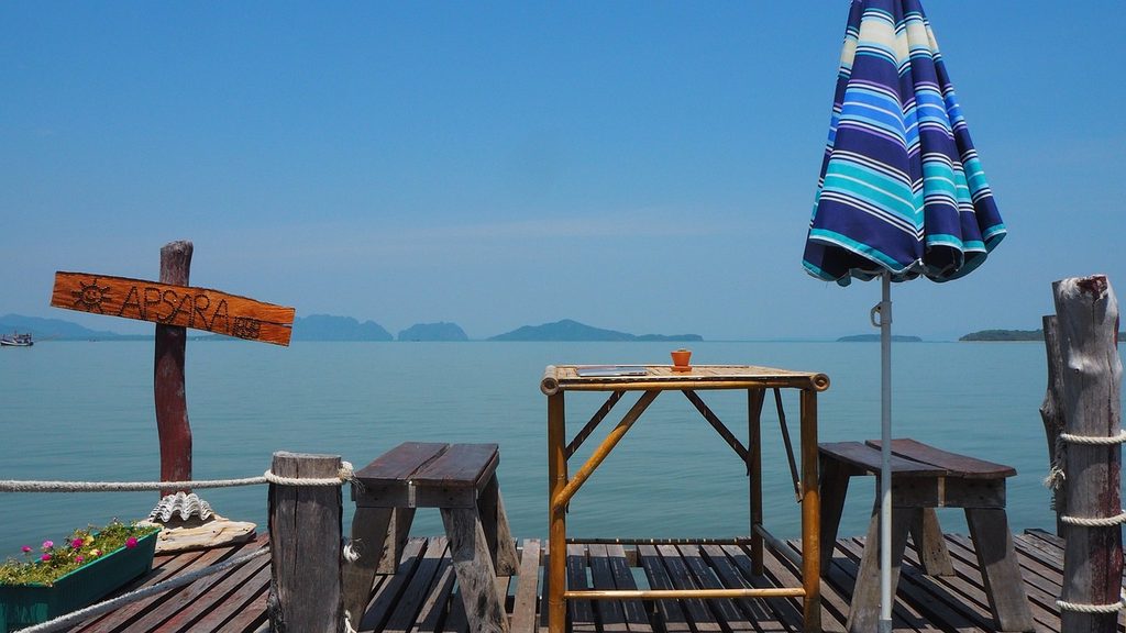Wooden dining terrace overlooking the sea and distant islands on Koh Lanta.
